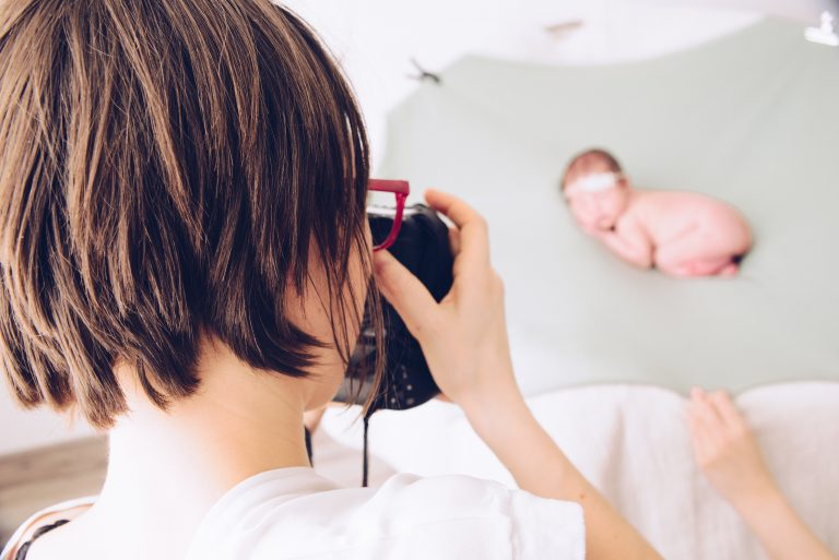 Elisa Baron photographiant un nouveau-né au studio, vue des coulisses